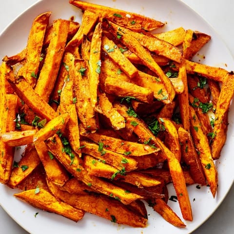 This image shows a serving of hot, flavorful Cajun Spiced Sweet Potato Fries, perfectly seasoned and delicious.