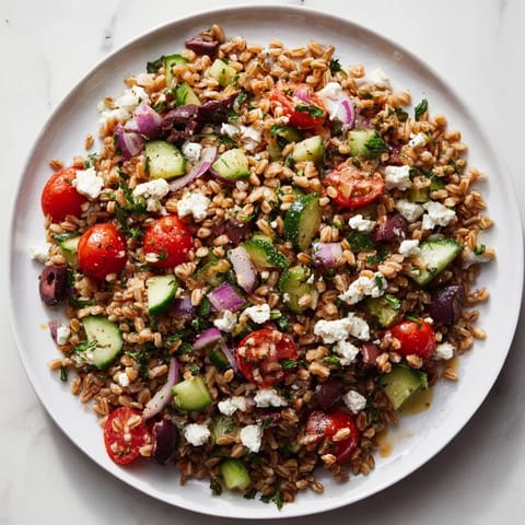 A refreshing Farro Salad Mediterranean featuring plump farro, drizzled with zesty lemon-oregano dressing.