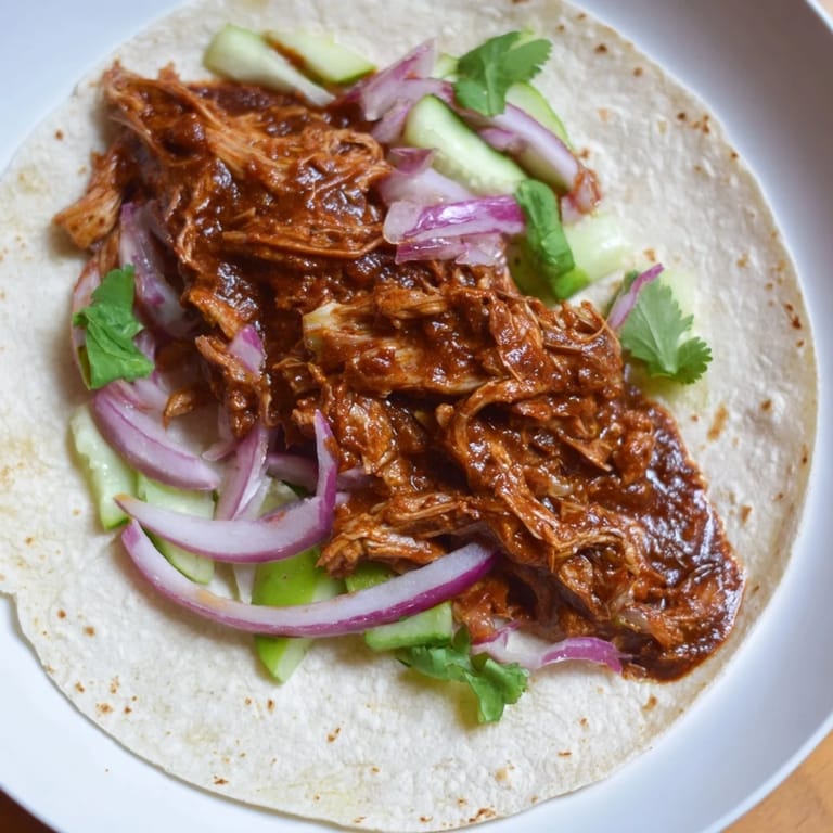 Tender chicken tikka masala nestled in soft taco shells, ready for a delightful bite.