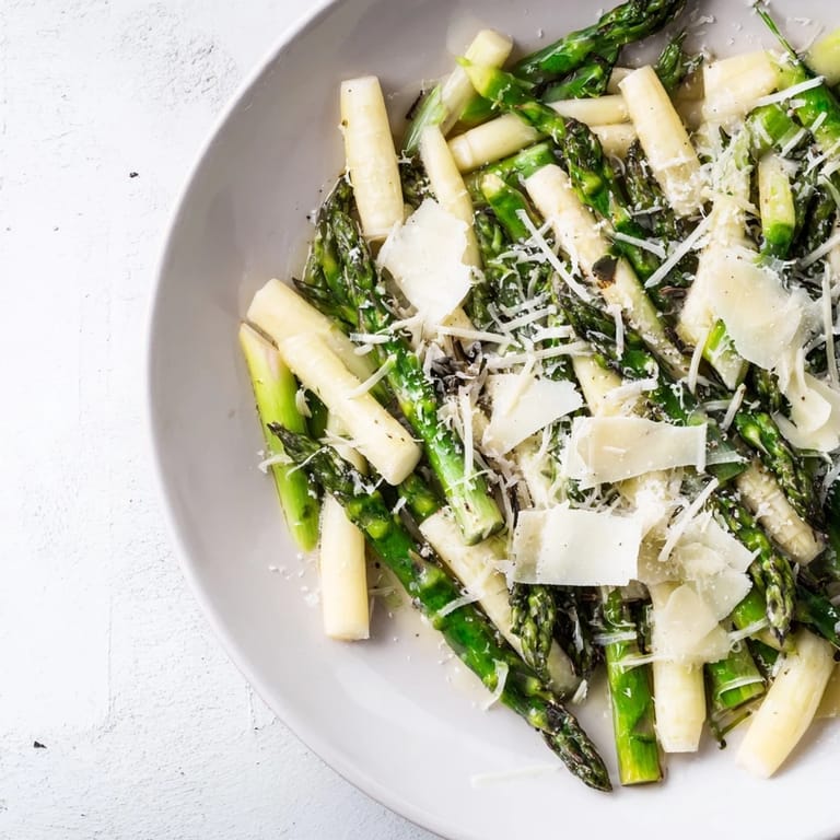 Elegant plating of The Silver Birch: white asparagus, creamy burrata, and earthy black truffle accents.