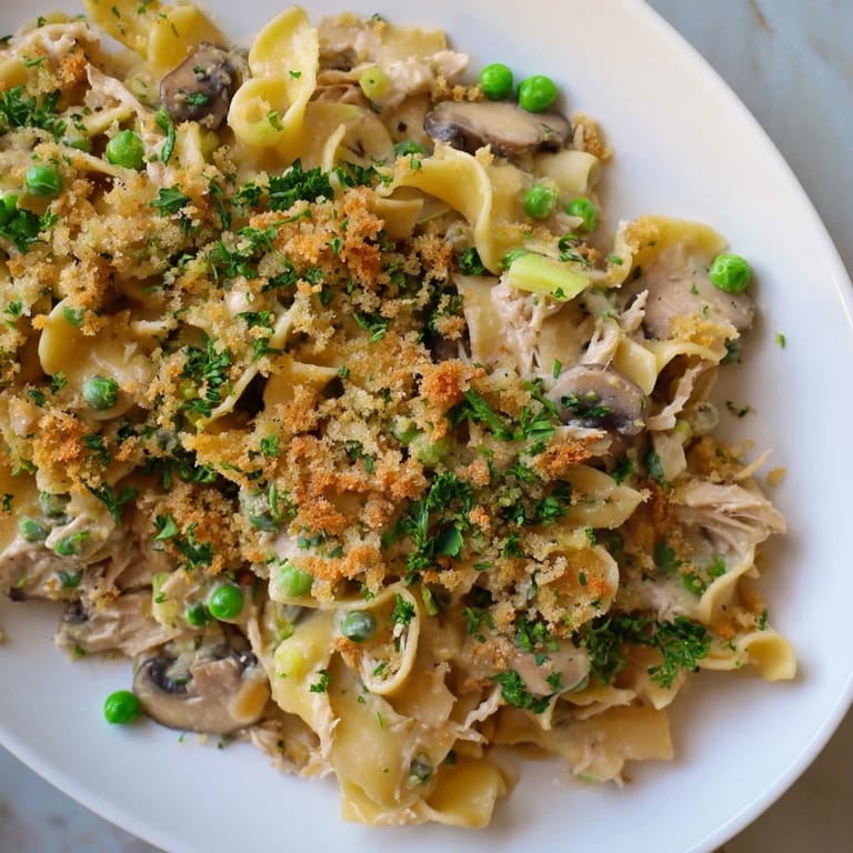 Bubbling Tuna Noodle Casserole 2.0, with visible peas and mushrooms, topped with crispy panko.