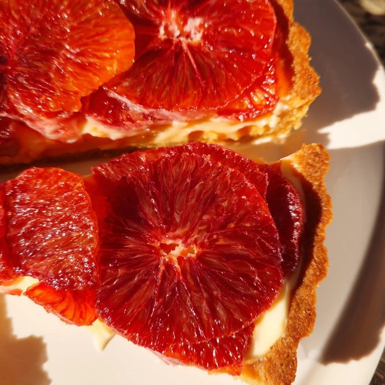 Golden Blood Orange Tarts topped with juicy citrus rounds, perfect for a French-inspired dessert spread.