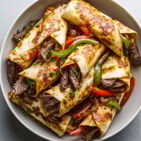 A plate of keto Philly cheesesteak roll ups.