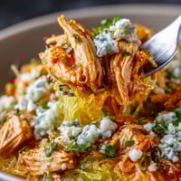 A bowl of food with a spoon in it.
