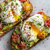 Two pieces of toast with poached eggs and everything spice.